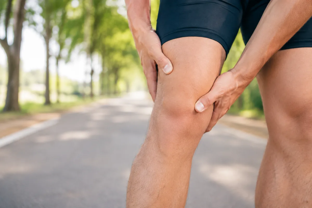 Gros plan sur la cuisse arrière d'un sportif appliquant une poche de glace apaisante