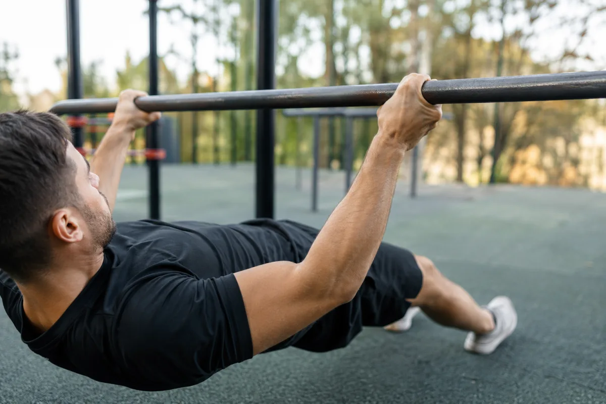 Gros plan sur les mains en prise pronation serrant fermement une barre d entrainement